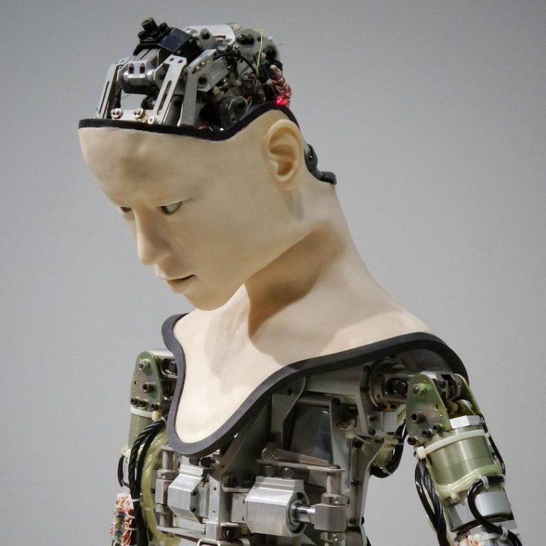 Ein humanoider Roboter mit sichtbaren mechanischen Komponenten und einem ausdruckslosen Gesicht. Ein humanoider Roboter mit sichtbaren mechanischen Komponenten und einem ausdruckslosen Gesicht.